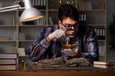 Arkeolog geç saatlere kadar ofiste çalışıyor.