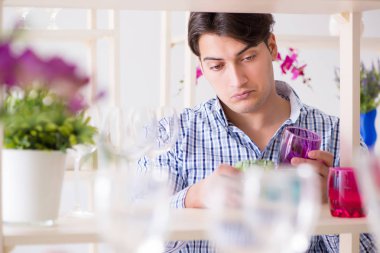 Genç yakışıklı dükkândan alışveriş yapıyor.