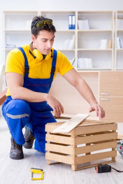 Tamirci marangoz ahşap tahtayı inceliyor.