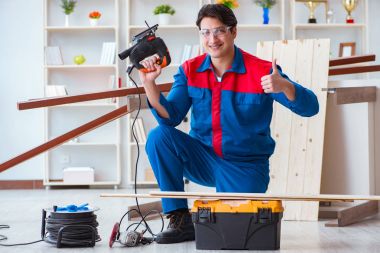 Genç marangoz ahşap kalaslarla çalışıyor.