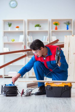 Genç marangoz ahşap kalaslarla çalışıyor.