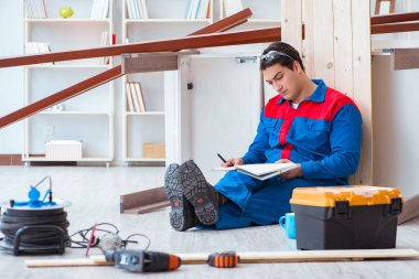 İnşaatta defter planlama yapan genç bir marangoz.