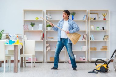 Adam evi temizliyor.