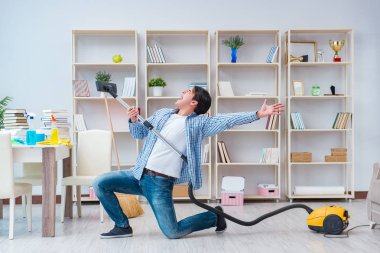 Adam evi temizliyor.