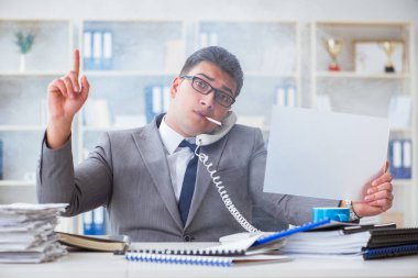 Ofiste sigara içen bir iş adamı elinde boş bir mesaj tutuyor.