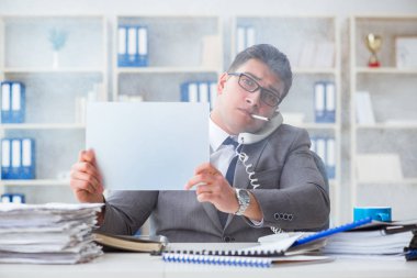 Ofiste sigara içen bir iş adamı elinde boş bir mesaj tutuyor.