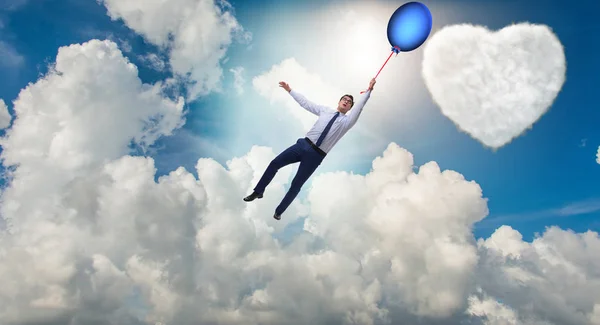Человек летит на воздушных шарах в романтической концепции — стоковое фото