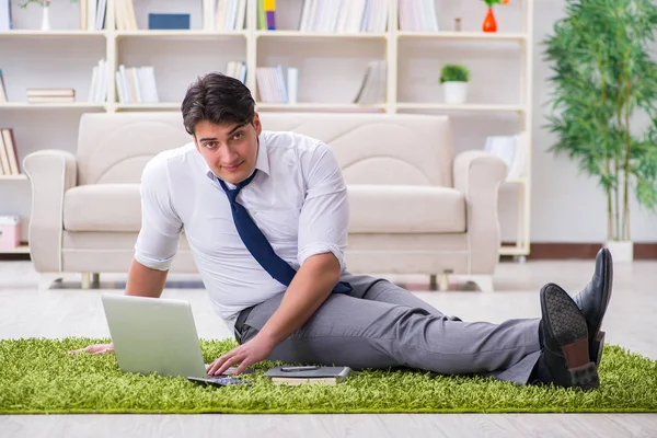 İş adamı ofiste yerde oturuyor.