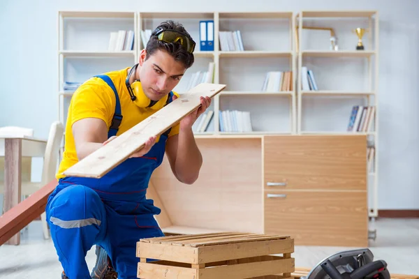 Tamirci marangoz ahşap tahtayı inceliyor.