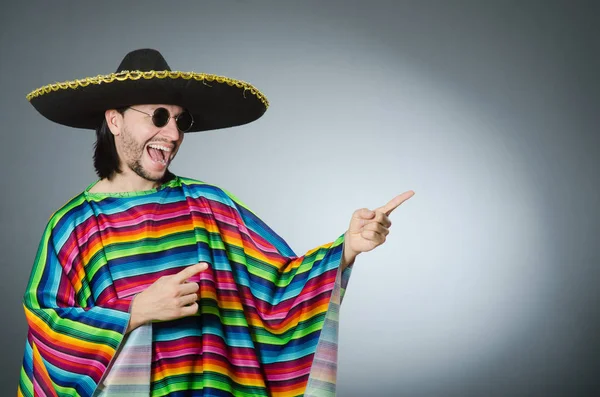 Людина в яскравому мексиканському пончо сірому фоні ізольована — стокове фото