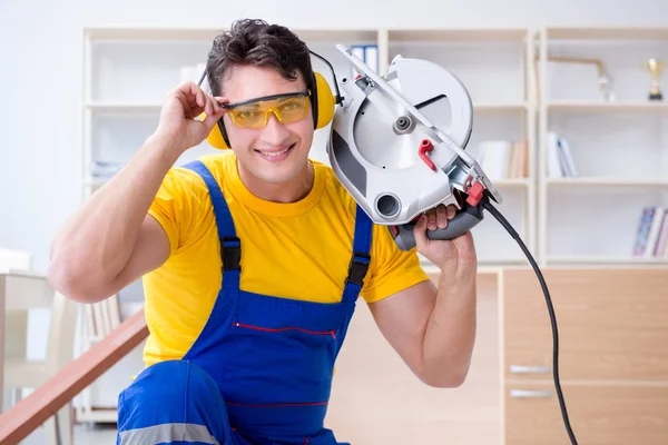 Repairman carpenter cutting sawing a wooden plank with a circula — Stock Photo, Image