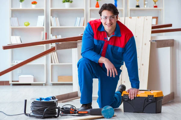 Genç marangoz ahşap kalaslarla çalışıyor.