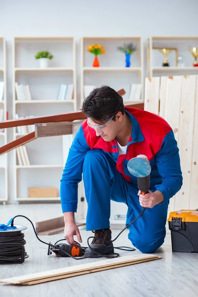 Genç marangoz ahşap kalaslarla çalışıyor.