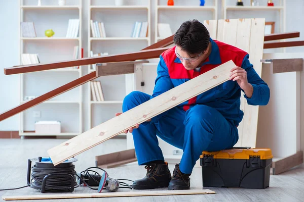 Genç marangoz ahşap kalaslarla çalışıyor.