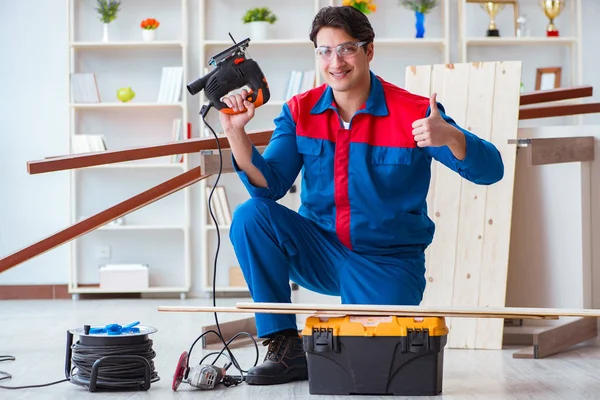 Genç marangoz ahşap kalaslarla çalışıyor.