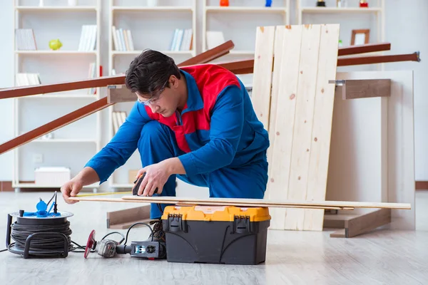 Genç marangoz ahşap kalaslarla çalışıyor.