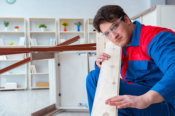 Genç marangoz ahşap kalaslarla çalışıyor.