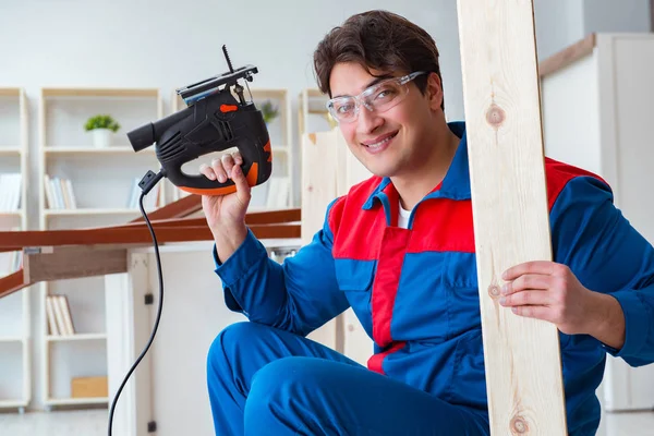 Genç marangoz ahşap kalaslarla çalışıyor.