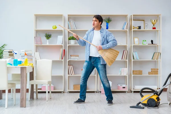 Adam evi temizliyor.