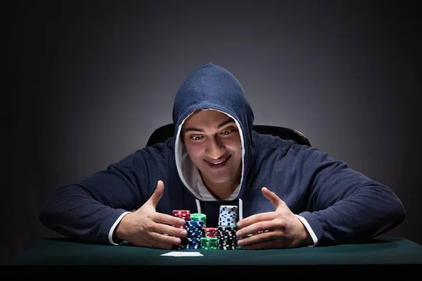 Jongeman draagt een hoodie met kaarten en chips gokken — Stockfoto