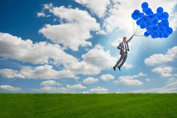 Hombre de negocios volando globos en día brillante — Foto de Stock