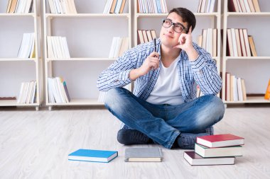 Genç öğrenci kitaplarla çalışıyor.