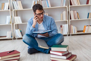 Genç öğrenci kitaplarla çalışıyor.