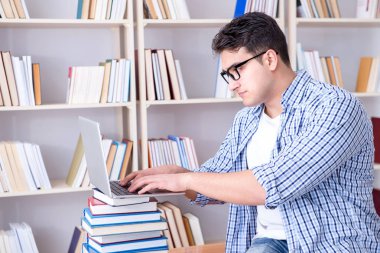 Kitapları olan genç bir öğrenci sınavlara hazırlanıyor.