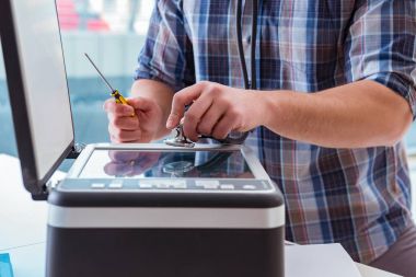 Tamirci bozuk renk yazıcısını tamir ediyor