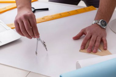 Erkek mühendis çizimler ve planlar üzerinde çalışıyor.