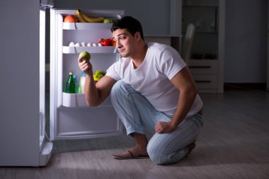 Buzdolabındaki adam gece yemek yiyor.