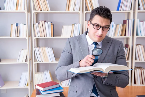 Студент бізнес-права зі збільшувальним склом читає книгу — стокове фото