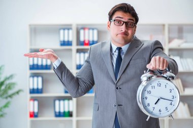 Ofiste çalar saati olan bir iş adamı var.