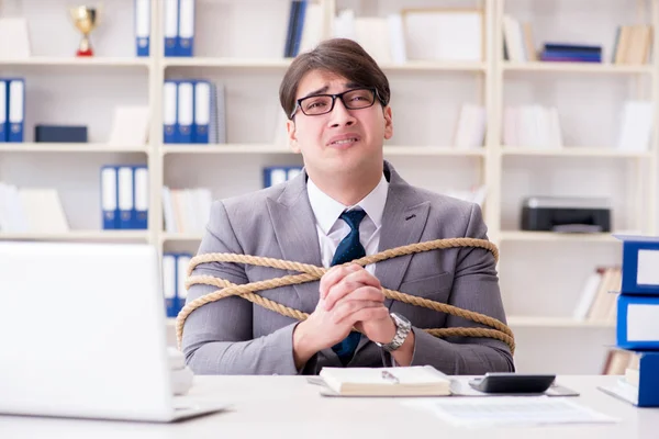 Businessman tied up with rope in office — Stock Photo, Image