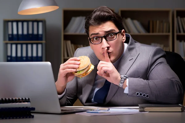 Empresario tarde en la noche comiendo una hamburguesa — Foto de Stock