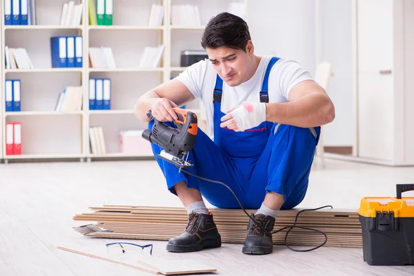 Trabajador joven que trabaja en baldosas laminadas piso — Foto de Stock