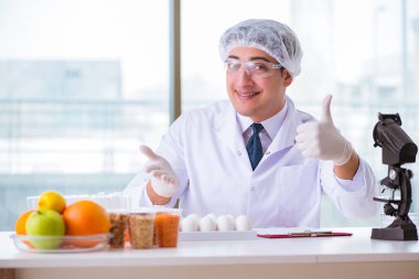 Besin uzmanı gıda ürünlerini laboratuarda test ediyor.