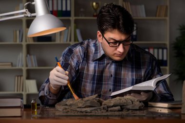 Arkeolog geç saatlere kadar ofiste çalışıyor.