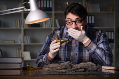 Arkeolog geç saatlere kadar ofiste çalışıyor.