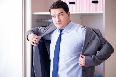 Genç işadamı iş için giyiniyor.