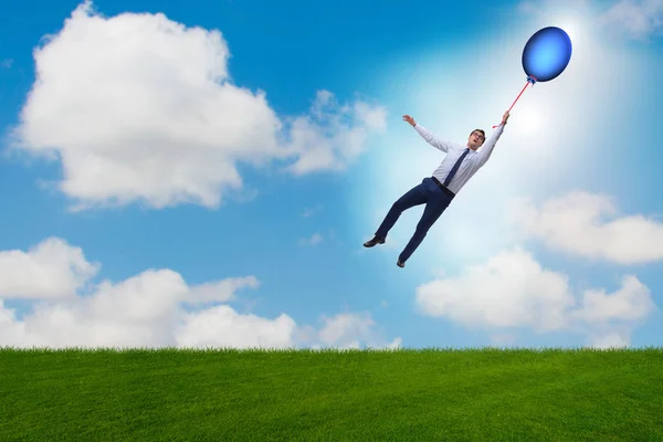 Бізнесмен літає повітряними кулями в яскравий день — стокове фото