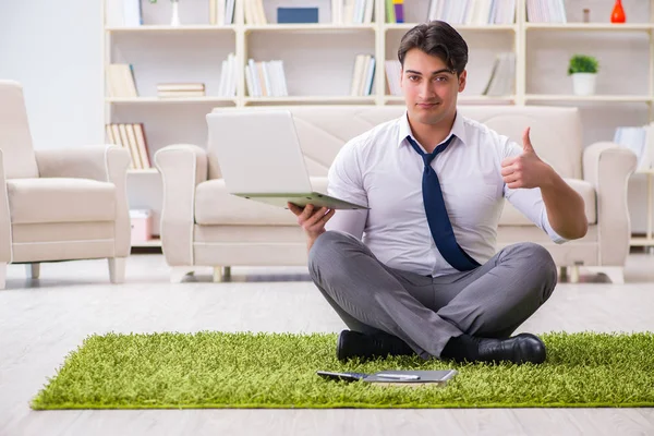 İş adamı ofiste yerde oturuyor.