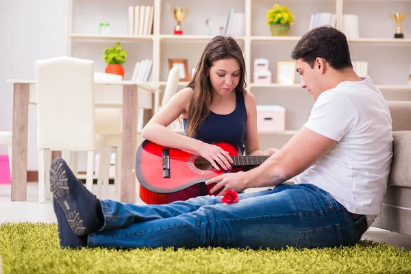 Coppia romantica che suona la chitarra sul pavimento — Foto Stock