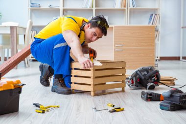 Tamirci marangoz tahta ve ölçü tahtasıyla çalışıyor.