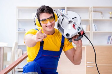 Tamirci marangoz. Dolaşım halindeki tahta testereyi kesiyor.