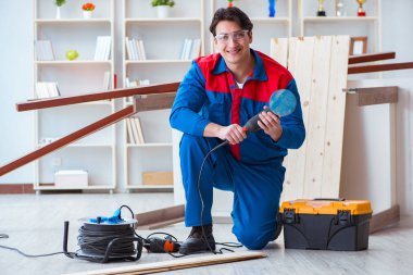 Genç marangoz ahşap kalaslarla çalışıyor.