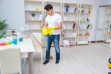 Adam evi temizliyor.