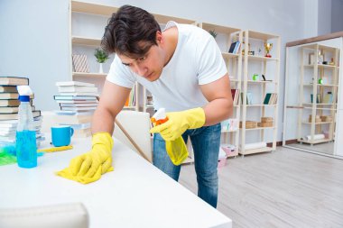 Adam evi temizliyor.