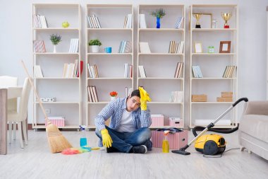 Adam evi temizliyor.