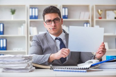 Ofiste sigara içen bir iş adamı elinde boş bir mesaj tutuyor.